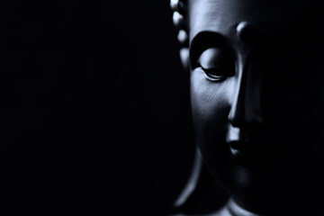 Meditating Buddha Statue isolated on black background. Copy space.