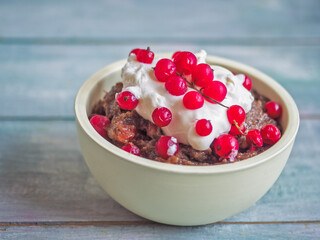 Bread soup with whipped cream and red currant berries in a deep cup