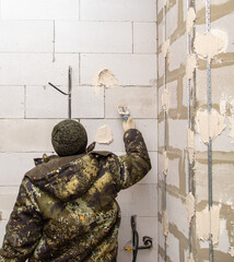 A worker plasters the walls