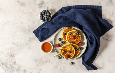 Tasty american pancakes with raspberries, blueberries, and honey. Breakfast concept with copy space.