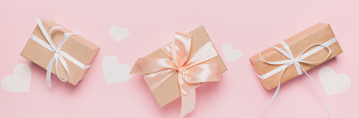 Gifts with wihte ribbon on isolated pink background