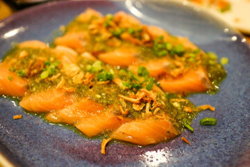 Fried garlic on spicy Salmon on blue plate
