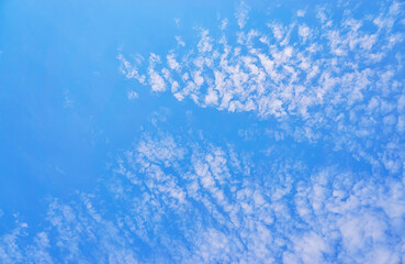 Fototapeta na wymiar Blue background with spots of white clouds.