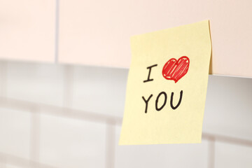 Romantic declaration of love on a sticky note in the interior of the kitchen. Love confession. Valentine's day celebration. Sticky note with phrase I love you!