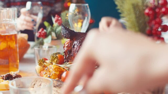 Roasted turkey on Christmas table, closeup. Christmas table to baked chicken. Family hands take food on christmas table with forks