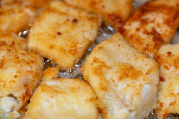 Breaded tender cod fillet pieces are fried in a pan