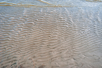 The texture of sand on the seashore after the wave came off.