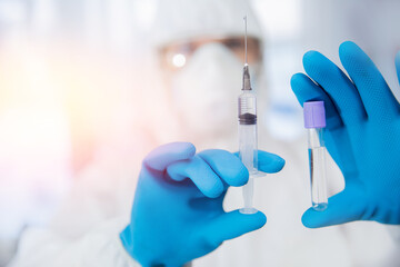 Concept Vaccination of people against dangerous virus Covid 19 coronavirus. Close-up nurse in protective suit holding syringe and vaccine