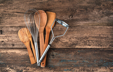 A set of cooking accessories on a wooden background. Top view with space to copy.