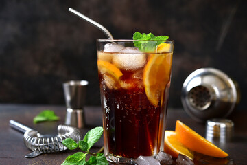 Cold summer soda cocktail with cola, dark rum and orange.