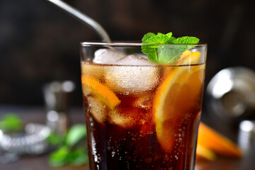 Cold summer soda cocktail with cola, dark rum and orange.