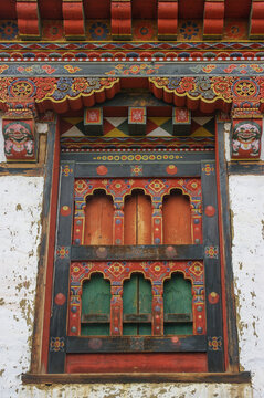Beautiful intricate traditional window wood carving with painted snow lions serving as protectors in Gangtey monastery in the high Phobjikha valley in Central Bhutan