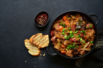 Bigos - traditional dish of polish cuisine,stewed cabbage with meat, sausage and dried mushrooms. Top view with copy space.