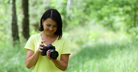 Female photographer take photo with a professional camera outdoor, World photographer day, Young woman with a camera in hand.