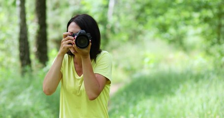 Female photographer take photo with a professional camera outdoor, World photographer day, Young woman with a camera in hand.