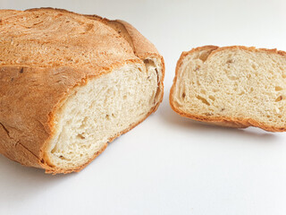loaf of bread.  Closeup freshly baked homemade traditional bread on white background. Concept - Cooking at Home. Sliced fresh bread 