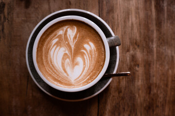 Cup of coffee on the wooden table. Cafe