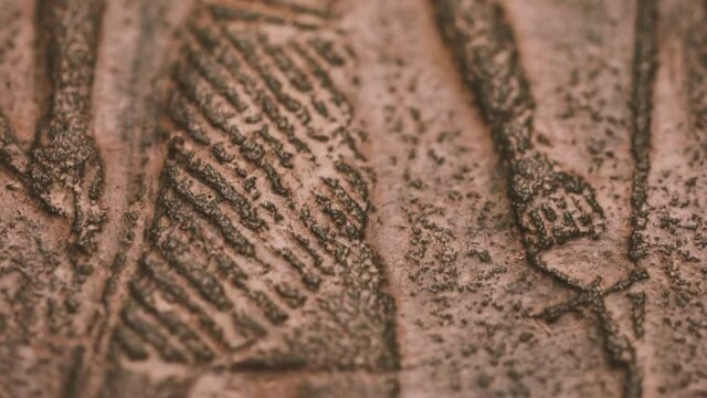 Shallow depth of field (selective focus) and close up footage with Egyptian hieroglyphs on a historic replica.