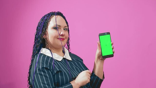Stylish brunette with blue afro braids leafing through the smartphone screen green screen. Medium plan