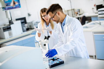 Group of young researchers analyzing chemical data in the laboratory