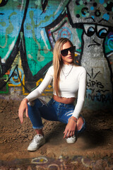 blonde sexy woman with sunglasses on wall with graffiti