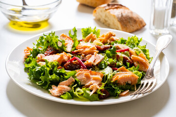 Salmon salad - roasted salmon with mix of vegetables on white background

