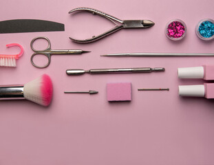 Naklejka premium Set of manicure tools and accessories on a pink background. Hardware manicure,Flat lay.