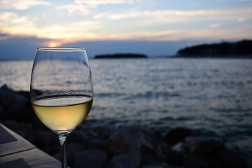 Lampka białego wina na tle zachodu słońca