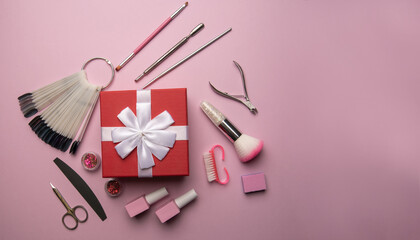 Set of manicure tools and accessories with red gift box on a pink background. Hardware manicure,Flat lay.