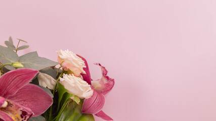 Fototapeta premium Close up of a bouquet of flowers, rose, eucalyptus, eustoma, orchid on a pink background. Place for text. Background. Wallpaper. Mothers Day. Postcard. Birthday. Advertising. Florist.