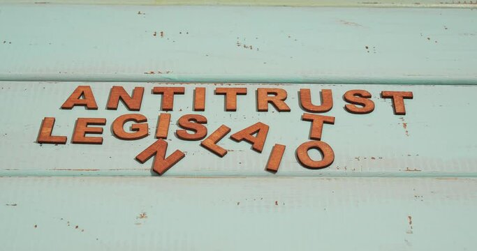 A text Antitrust Legislation made from wooden letters on wooden table.