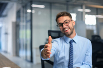 Fototapeta premium Business man with an open hand ready to seal a deal in office.
