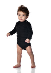 boy walks making the first step. Cute barefoot baby learns to walk. Isolated portrait shot against a white studio background. Happy childhood and generation. Growth and development of the baby