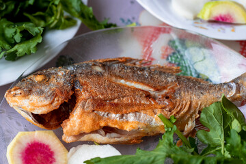 Sea bream fried fish, arugula, cress, white radish.