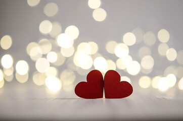 Two red wooden hearts on bokeh background