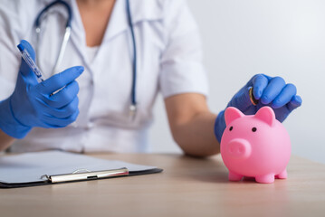 A faceless female doctor puts a coin in a piggy bank