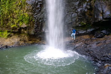 Man standing next to a waterfall in the Aberdare Ranges, Kenya