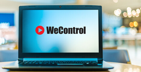 Laptop computer displaying 'we control' sign