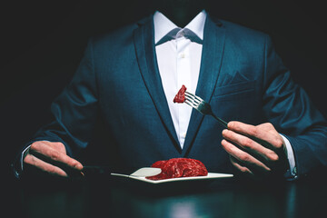 Supper of blue blood aristocrat. Portrait of handsome,young man eating fresh meat . Classical suit....