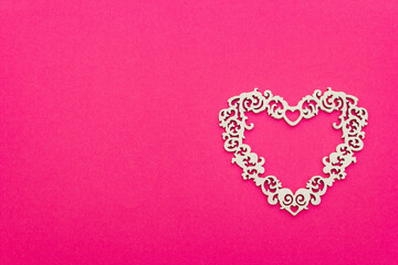 Festive composition with openwork white heart on pink background