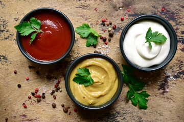 Set of popular sauces in a black bowls . Top view with copy space.