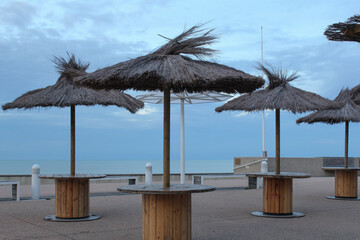 Fototapeta premium a terrace along the sea at the french coast in normandy in summer with a lot of parasols and a blue sky and sea in the background