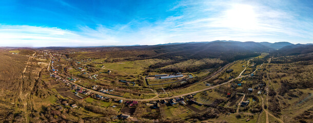 aerial panorama - a small village of Neberdzhaevskaya among the low hills of the foothills of the Western Caucasus (South of Russia) - on a sunny winter day
