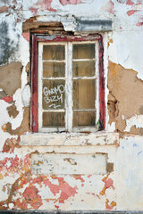 Broken Window and Frame in Derelict Building with Flaking Wall Paint