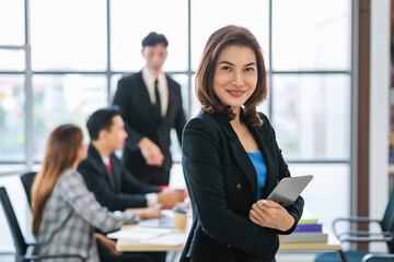 businesswoman standing smilling with holding mobile