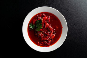 Traditional ukrainian beetroot soup borscht on a minimalistic black background, directly above