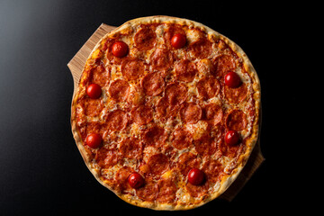 Top view of hot pepperoni pizza on black background, copy space