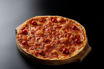 Hot oven-made pepperoni pizza with ,melted mozzarella cheese on smooth black background