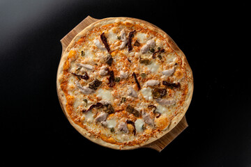 Top view of chicken and mushroom pizza with melted bright yellow cheddar cheese