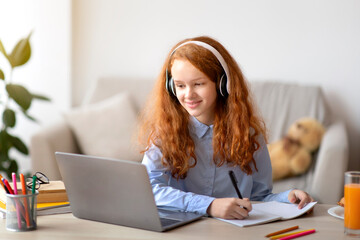 Girl wearing headphones using laptop for elearning